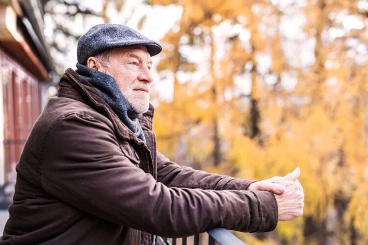 Happy senior man resting on a terrace in autumn nature. Happy senior man resting on a terrace in autumn nature.