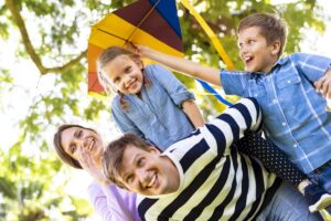 family-playing-with-a-colorful-kite-3JHUS8E family-playing-with-a-colorful-kite-3JHUS8E
