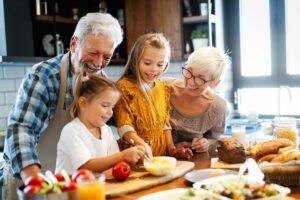 Happy senior couple having breakfast with their grandchildren at home