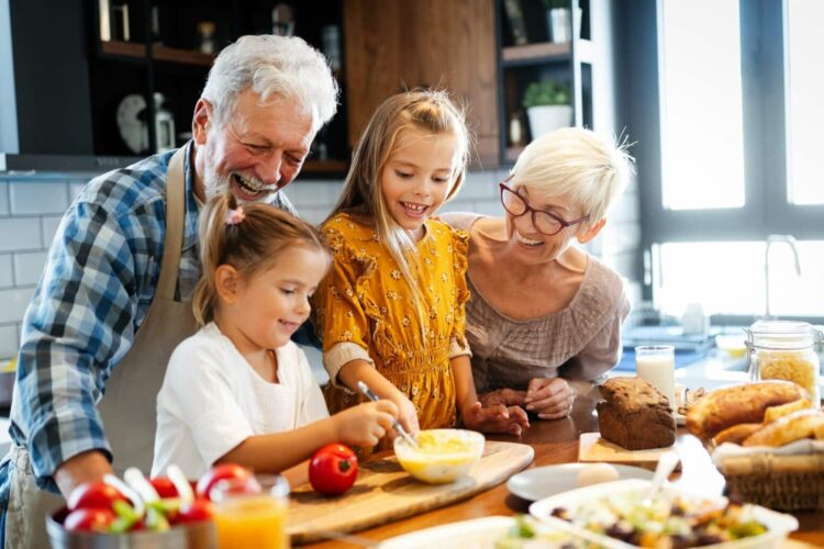 Happy senior couple having breakfast with their grandchildren at home Happy senior couple having breakfast with their grandchildren at home